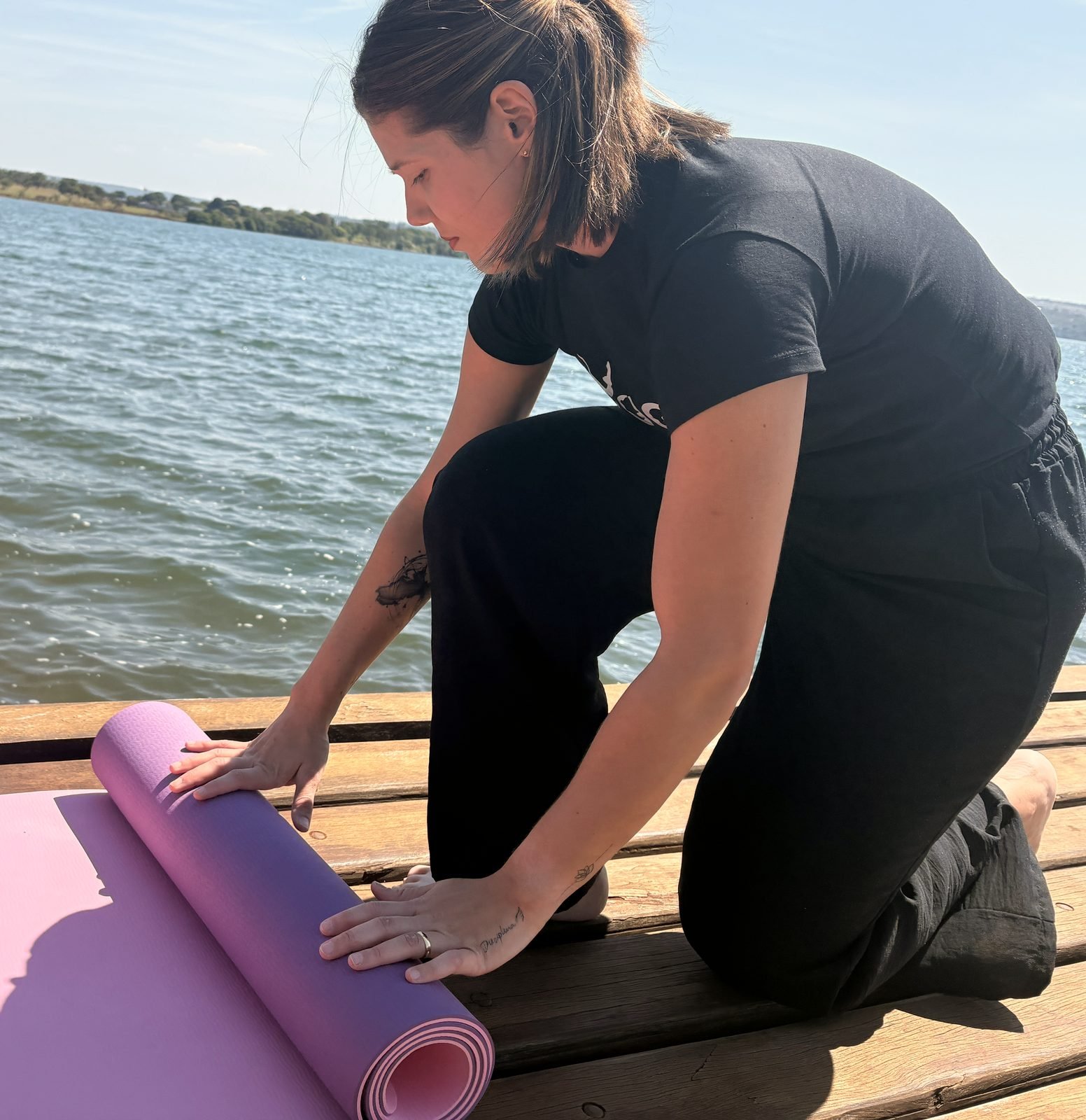 Jhennyfer desenrolando um tapete de yoga lilás